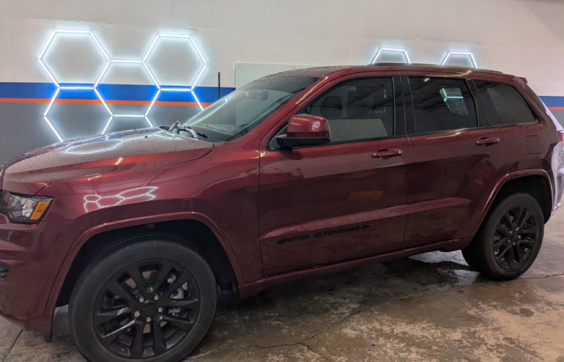 Jeep Grand Cherokee with fresh window tint under the shop lights